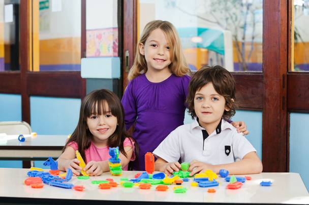 Cute Friends With Blocks On Desk In Classroom - Photo, Image