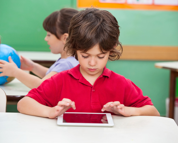 Boy Using Digital Tablet At Desk - Foto, Bild