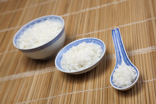 Bowl of white rice on tatami mat - Фото, изображение