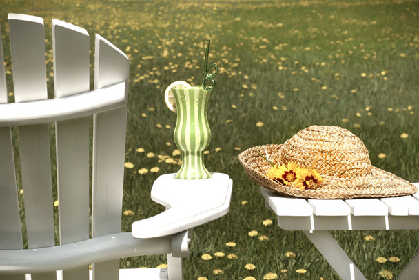 涼しい夏の飲み物と草の上のアディロンダックの椅子 - 写真・画像