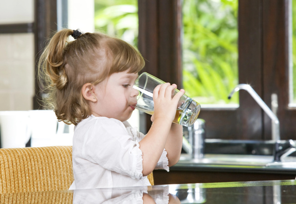 Πορτρέτο του μικρού κοριτσιού που πίνει στο οικιακό περιβάλλον - Φωτογραφία, εικόνα