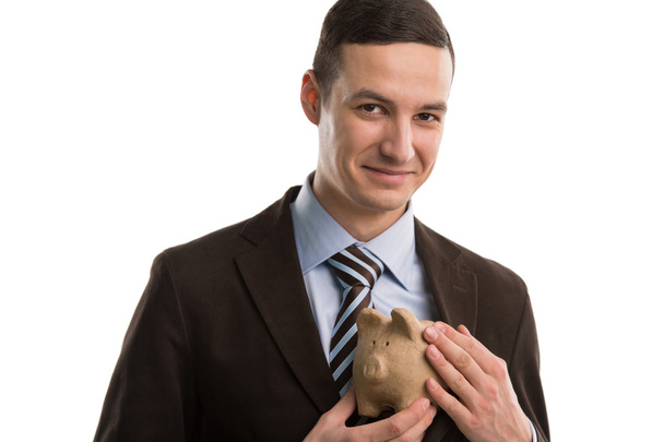 Business man hiding piggybank - Foto, afbeelding
