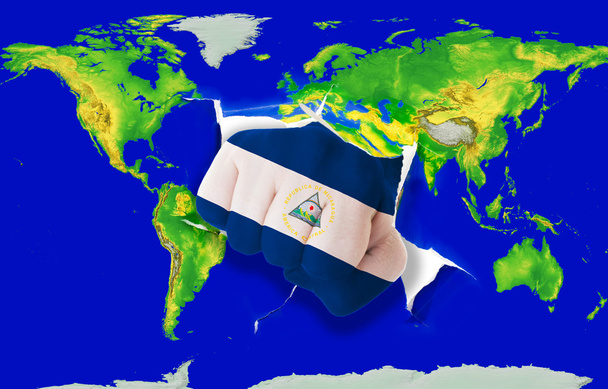 Faust in Farbe Nationalflagge Nicaraguas beim Stanzen der Weltkarte - Foto, Bild