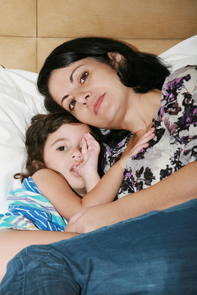красивая молодая мать с дочерью на кровати
 - Фото, изображение