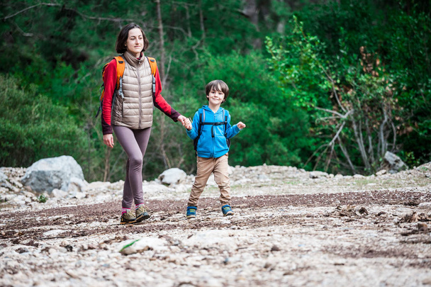 Uma mulher caminha com seu filho pela floresta
.  - Foto, Imagem
