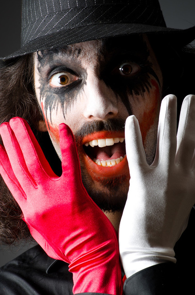 Joker personification with man in dark room - Foto, afbeelding