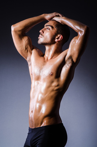 Muscular man in dark studio - Valokuva, kuva