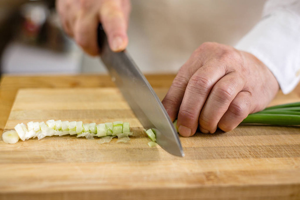  o chef corta cebola verde
 - Foto, Imagem