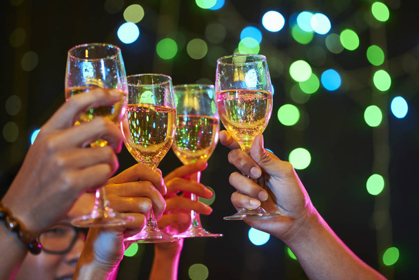 Grupo de pessoas torcendo com copos de vinho espumante na festa
 - Foto, Imagem