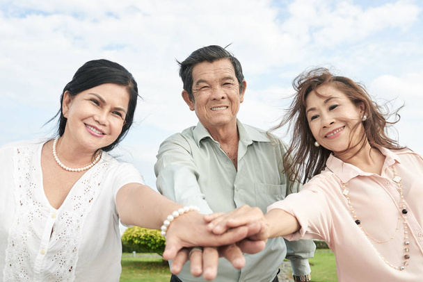 freudige Senioren reichen sich die Hände, um Einheit und Freundschaft auszudrücken - Foto, Bild