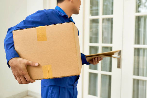 Mensajero entregando caja grande a casa del cliente
 - Foto, Imagen