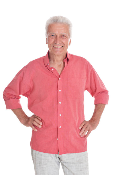 Smiling senior man wearing pink shirt holding hands on hips isolated on white background  - Fotoğraf, Görsel