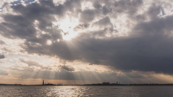 Статуя свободи над водою на заході сонця, в Нью-Йорку, США - Фото, зображення