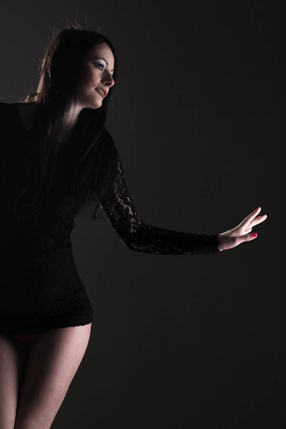 beautiful girl in black sexy clothes, against dark background - Fotó, kép