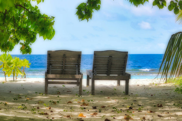 Esta imagem única mostra duas belas cadeiras de madeira velhas na praia natural das Maldivas com vista para o mar
 - Foto, Imagem