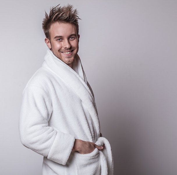 Handsome smiling young man in luxurious bathrobe. - Foto, Imagem