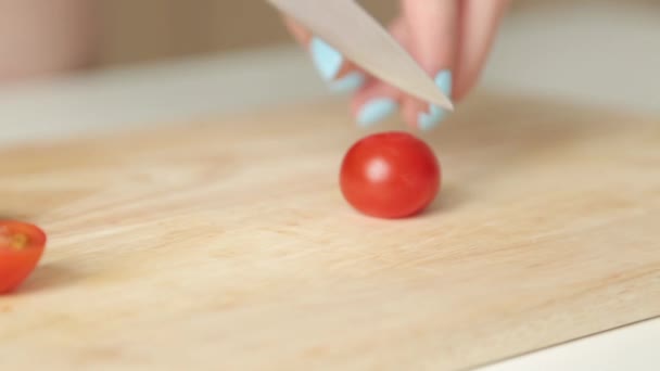 Slicing cherry tomatoes for salad. Cutting a tomato on a wooden Board. - Filmmaterial, Video