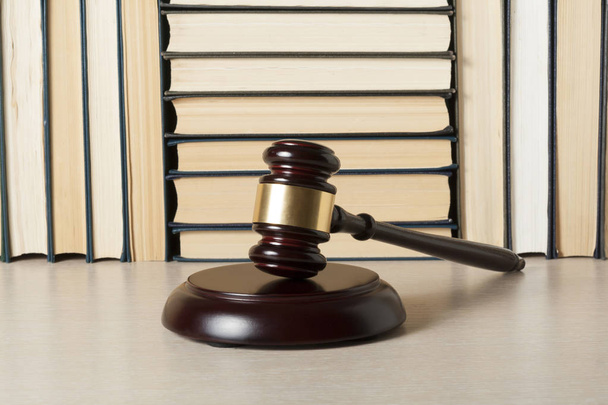 Έννοια του νόμου. Ξύλινος δικαστής σφυρί με νομικά βιβλία στο τραπέζι σε ένα δικαστήριο ή γραφείο επιβολής. - Φωτογραφία, εικόνα