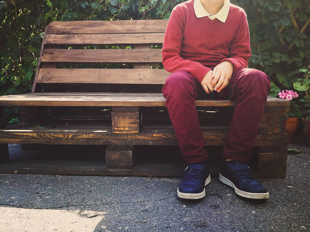 stylish boy sits on a wooden bench - Photo, Image