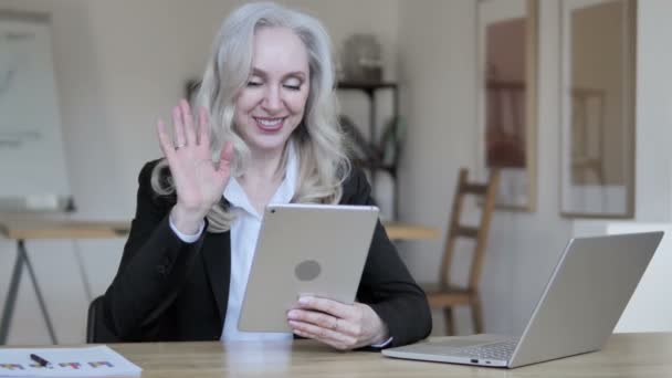 Chat de vídeo en línea por la mujer de negocios madura en la tableta
 - Metraje, vídeo
