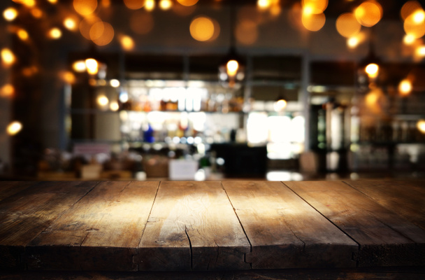 抽象的なぼやけたレストランライトの背景の前に木製のテーブルのマジ - 写真・画像