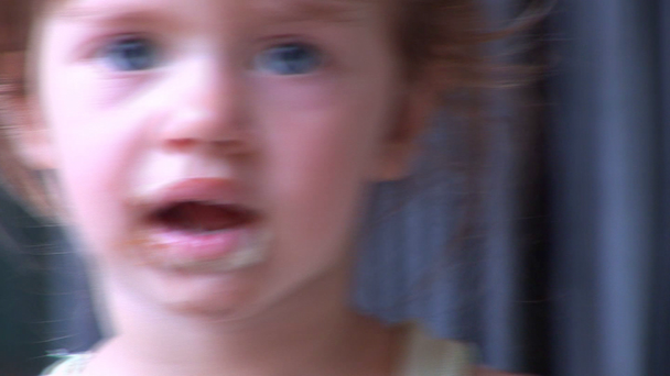 χαριτωμένο κορίτσι μπλε-eyed γλείφει ένα παγωτό - Πλάνα, βίντεο