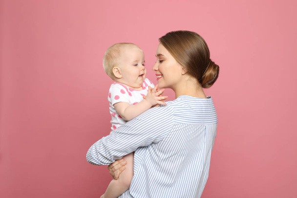 Portrait of happy mother with her baby on color background - Photo, image