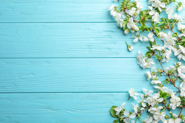 Flat lay composition of beautiful fresh spring flowers on wooden background, space for text - 写真・画像