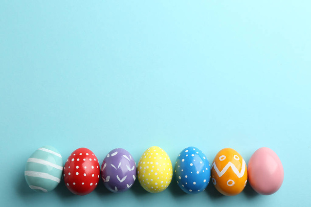 Flat lay composition of painted Easter eggs on color background, space for text - Fotoğraf, Görsel