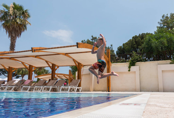 Boy jumping into the pool - Photo, Image