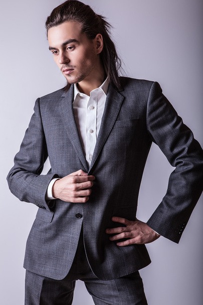Elegant young handsome long-haired man in costume. Studio fashion portrait. - Photo, image