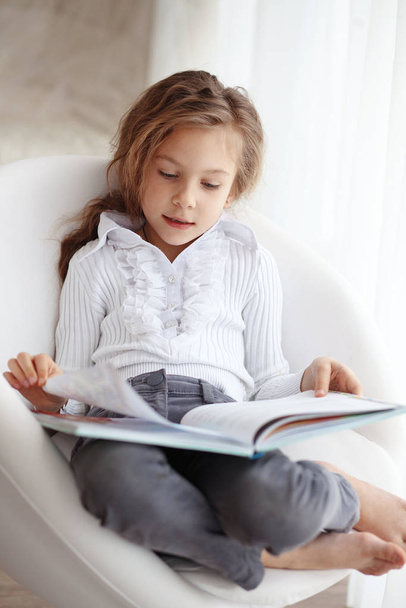 Portrait of 6 years old child reading book at home - Foto, Bild