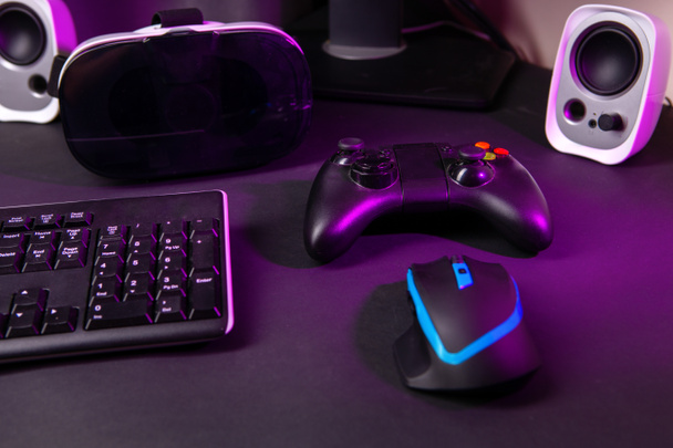 Vista superior de un equipo de juego, ratón, teclado, joystick, auriculares, VR auriculares sobre fondo de mesa negro
. - Foto, imagen