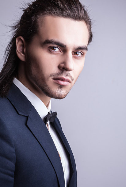 Elegant young handsome long-haired man in costume. Studio fashion portrait. - Fotoğraf, Görsel