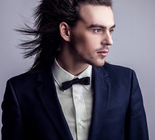 Elegant young handsome long-haired man in costume. Studio fashion portrait. - Foto, imagen