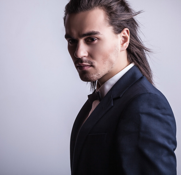 Elegant young handsome long-haired man in costume. Studio fashion portrait. - Foto, Imagen