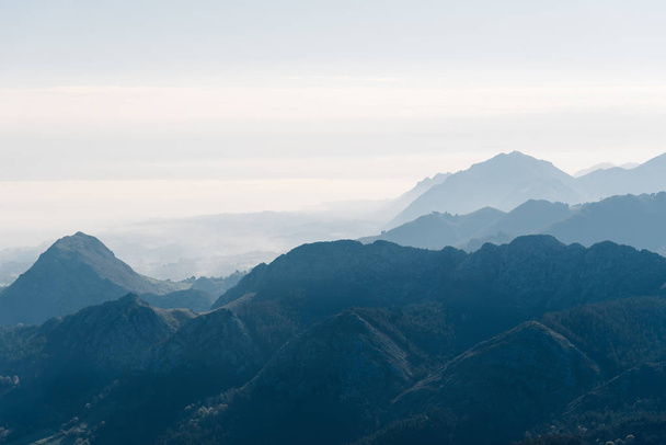 Scenic view of silhouettes of mountains in the morning mist - Foto, imagen