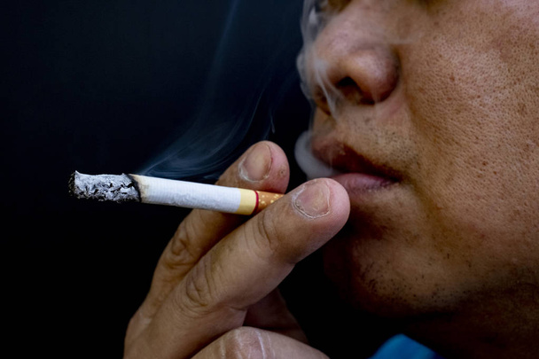 Homme fumant une cigarette, Image de cigarette à la main avec de la fumée
 - Photo, image