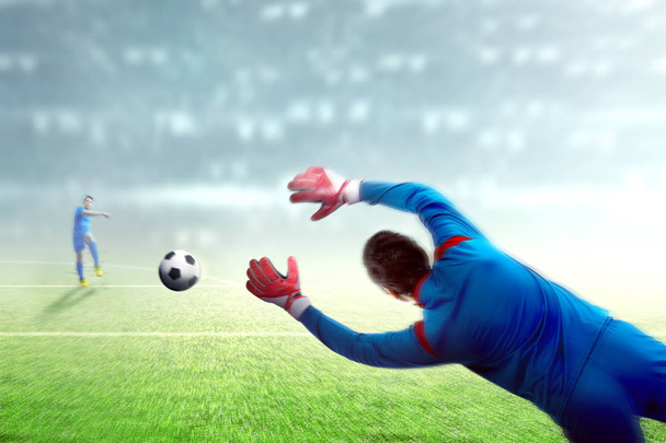 Asiático jugador de fútbol hombre pateando la pelota a la portería
 - Foto, Imagen