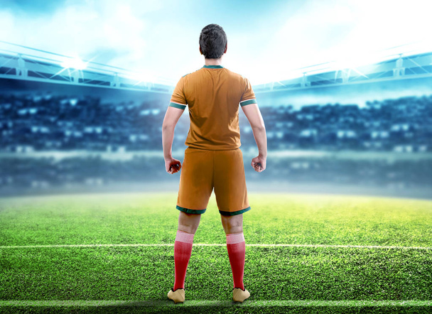 Rear view of football player man standing in the middle of footb - Photo, image