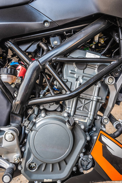 Closeup modern motorkerékpár motor detail rendszer fekete és barna színű. - Fotó, kép