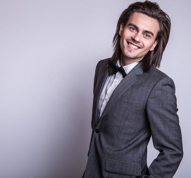 Elegant young handsome long-haired man in costume. Studio fashion portrait. - Фото, изображение