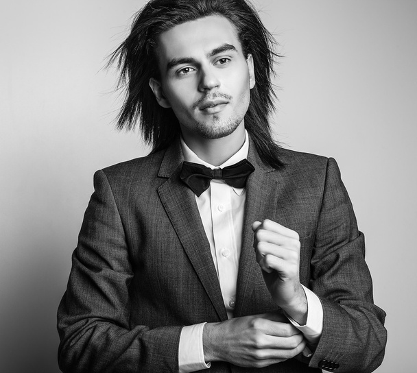 Elegant young handsome long-haired man in costume. Studio fashion portrait. - Фото, изображение