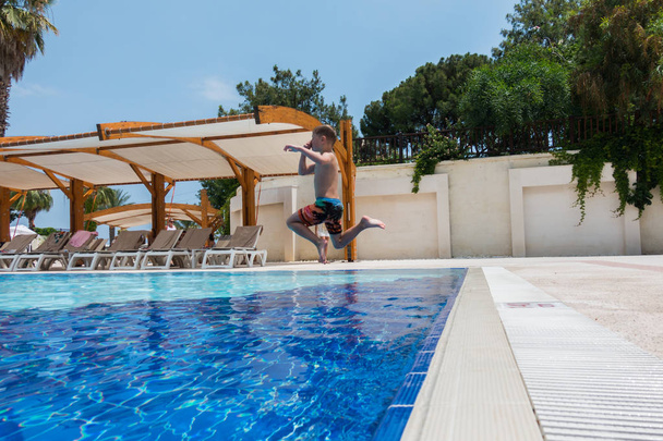 garçon sautant dans la piscine - Photo, image