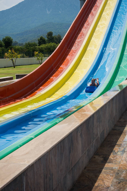 The boy rides a slide in the water park - Photo, Image