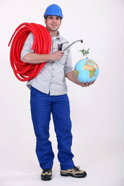 Plumber installing a worldwide water supply system - Photo, Image