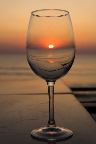 gündoğumu deniz kıyısında şeffaf bir cam yansıyan ve oce - Fotoğraf, Görsel