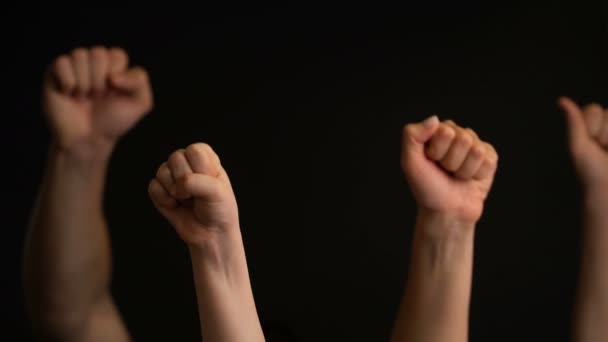 Raising hands with fists on black background. - Footage, Video