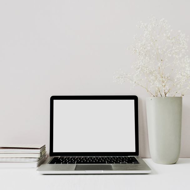 Espaço de trabalho de mesa de escritório em casa minimalista com laptop, buquê de flores no fundo rosa. Cabeçalho herói vista frontal com espaço em branco cópia
. - Foto, Imagem