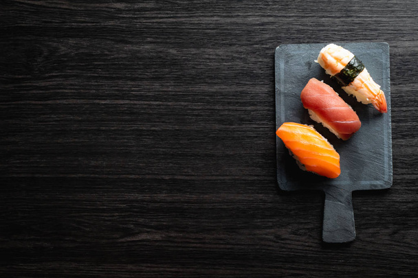 Nigiri sushi on wood table in a japanese restaurant. Copy space and top view - Foto, imagen